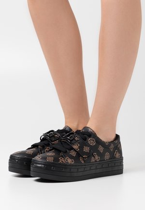 Black platform sneakers with embossed brown patterns, round toe, and black laces. Features a thick rubber sole and textured upper material.