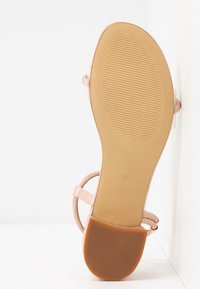 Sandale à talon haut beige avec une sangle en cuir lisse et une semelle en caoutchouc. La semelle a une texture antidérapante avec la taille 37 embossée dessus.