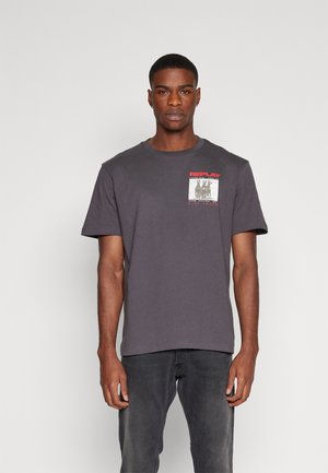Camiseta de algodón gris oscuro con cuello redondo, mangas cortas y un gráfico en el pecho. El diseño presenta una impresión colorida con la palabra "REPLAY."