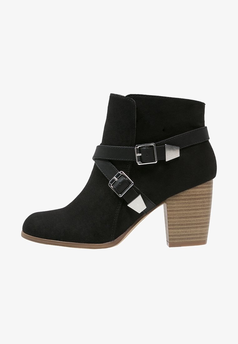 Bottine en daim noir avec deux brides décoratives noires et boucles argentées, talon empilé en bloc de bois et bout arrondi.