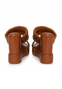 Sandalias de plataforma marrones con un diseño de tiras retorcidas, hechas de un material brillante; tacones gruesos y chunky con un acabado suave.