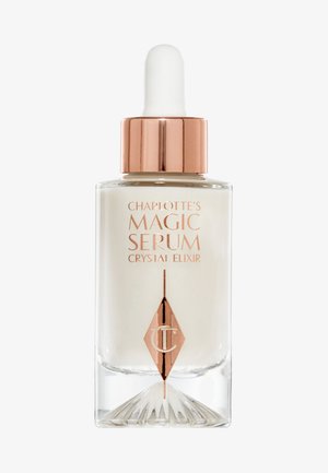 Bottiglia di vetro con pipetta contenente siero bianco, con accenti dorati e base angolare. L'etichetta presenta un testo in rosa oro, evidenziando il nome del prodotto.