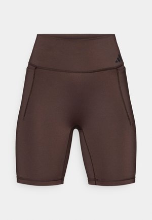 Shorts de sport marron avec une taille haute, fabriqués en tissu lisse. Ils comportent des poches latérales et un logo noir sur la ceinture.