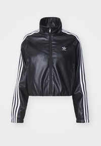 Svart kort jacka i konstläder, med hög krage, dragkedja framtill och vita Adidas tre-randiga detaljer på ärmarna.