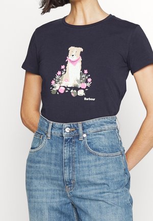 Marineblaues Baumwoll-T-Shirt mit einer Grafik eines Hundes mit einem pinken Schal, umgeben von Blumen, kombiniert mit hellblauen, hoch taillierten Jeans.