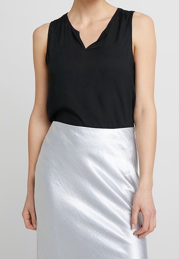 Black sleeveless top with a v-neck, paired with a shiny silver skirt, featuring a smooth texture and a wrap design.