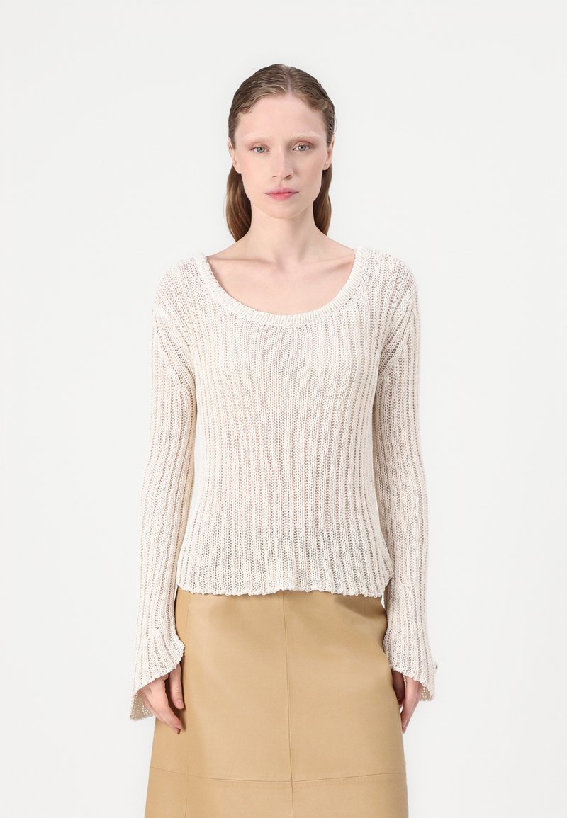 Maglione lavorato a maglia color beige chiaro con scollatura ampia, coste testurizzate, maniche lunghe a campana e orlo leggermente corto.