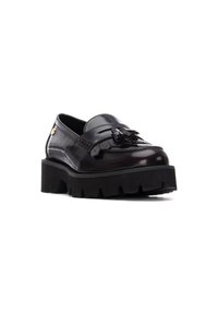 Mocasines de cuero negro con un acabado brillante, que cuentan con una banda texturizada y un detalle de lazo. Suela negra gruesa y resistente con detalles acanalados.