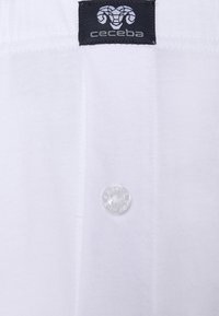 Witte katoenen overhemd met een heldere knop en een zwart label met een ram logo en de tekst "ceceba", dat een soepele textuur en klassiek ontwerp benadrukt.