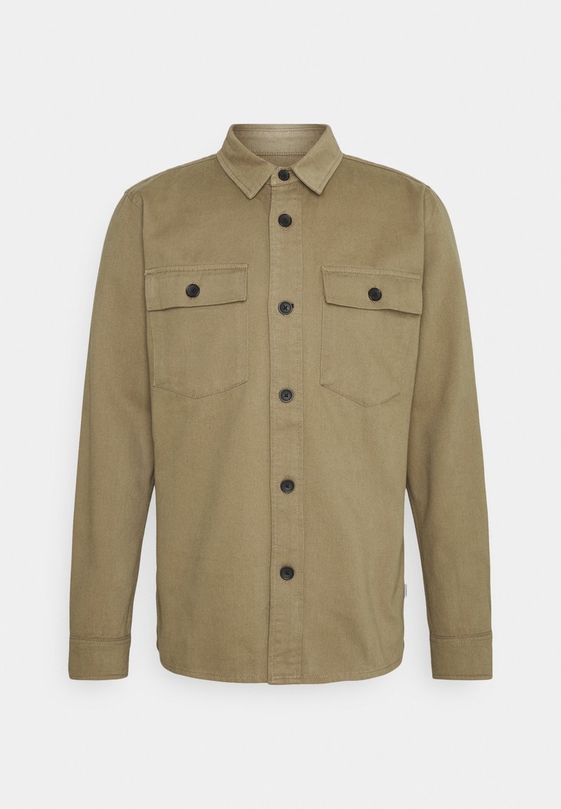 Veste-chemise kaki à manches longues avec fermeture à boutons sur le devant et deux poches poitrine à rabat boutonné sur un fond uni.