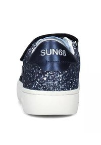 Sneakers glitterati blu navy con un tallone liscio di un blu scuro che presenta il logo "SUN68". Suola in gomma bianca, chiusura con strap in velcro.