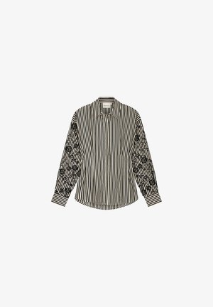 Black and white striped long-sleeve shirt with a solid striped pattern on the front and patterned embroidered detail on the sleeves.