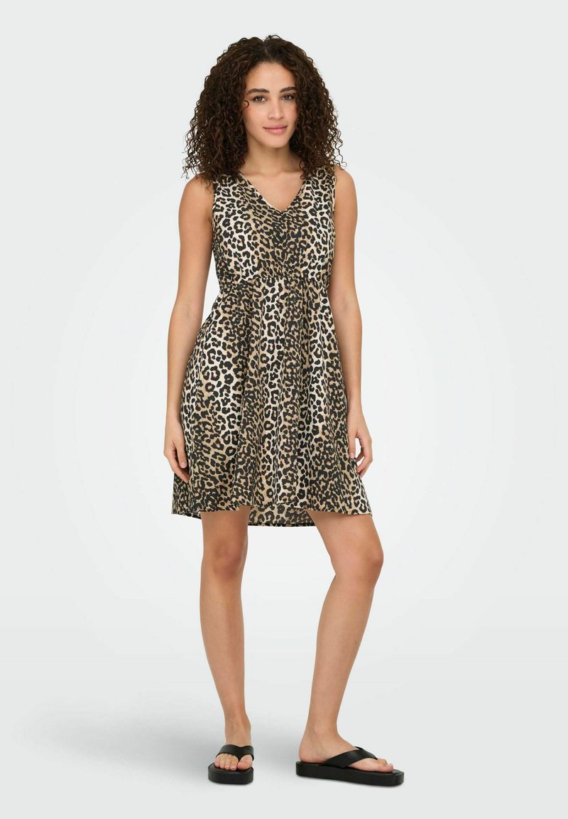 Leopardprint jurk met V-hals, mouwloos ontwerp en taillering. Lichtgewicht stof, knielang, gecombineerd met zwarte teenslippers.