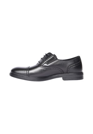 Scarpa elegante da uomo in pelle nera con dettagli brogue, chiusura con lacci chiusi e tacco basso, mostrata in profilo laterale su sfondo bianco.