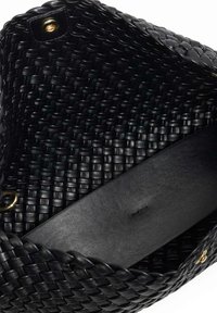 Black woven bag with a textured finish. Features a smooth black leather handle and gold hardware accents inside.
