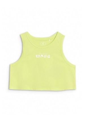 Dziewczyna z długimi ciemnymi włosami, ubrana w limonkową, bezrękawnikową bluzkę typu crop top, szare szorty z elastycznym pasem, białe skarpetki i fioletowe trampki, stoi z rękami w kieszeniach.