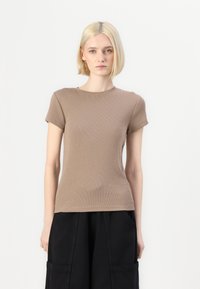 Ruda dryžuota trumpo rankovė t-shirt su apvaliu kaklu ir prigludusiu dizainu, derinama su laisvomis juodomis kelnėmis. Glotni tekstūra, šiek tiek elastinga.
