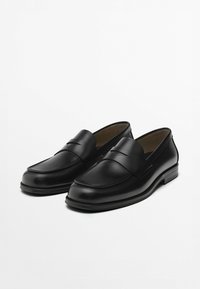 Schwarze Leder-Slipper mit glatter Oberfläche, genähten Akzenten, runder Zehenpartie und niedrigem Absatz. Ohne Schnürsenkel für einfaches Anziehen.