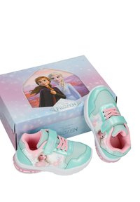 Παιδικά αθλητικά παπούτσια με θέμα το Frozen σε μέντα πράσινο και ροζ με λουλουδάτες λεπτομέρειες, δίπλα σε μια παστέλ κουτί με τους χαρακτήρες Άννα και Έλσα.