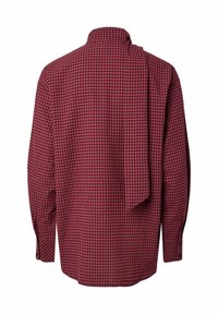 Chemise à manches longues rouge et noire à petits carreaux avec un col montant et une écharpe en tissu attachée qui pend dans le dos.