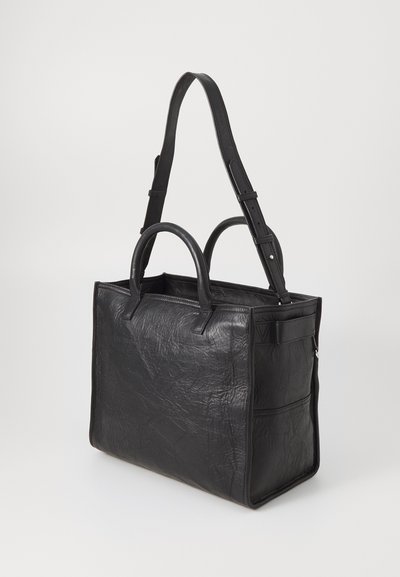 Black leather tote bag with a crinkled texture, dual top handles, and a detachable shoulder strap. Features side pockets for extra storage.