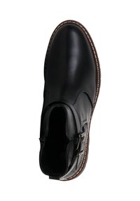 Bota de tobillo de cuero negro con punta redondeada, detalle de hebilla lateral y costuras en contraste blancas a lo largo de la suela. Textura suave, sin patrones visibles.