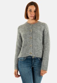 Suéter de punto gris con cuello redondo, mangas largas y cierre de botones. Textura suave con puños acanalados y un dobladillo ligeramente recortado.
