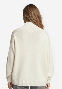 Dicker Strickpullover in Cremefarbe mit hohem Kragen, überschnittenen Schultern und geripptem Saum. Strukturierter Stoff mit einem lockeren, entspannten Schnitt.