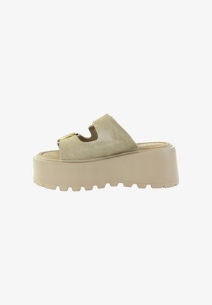 Beżowa sandałka na platformie z grubą gumową podeszwą, cholewką zamszową, odkrytymi palcami i dużą złotą klamrą na białym tle.