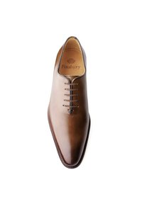 Chaussure de ville en cuir marron au design épuré, à bout pointu et à six œillets. L'intérieur présente une marque imprimée. Finition lisse avec un léger éclat.