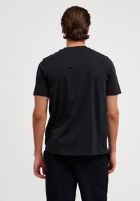Zwarte katoenen T-shirt met korte mouwen en een ronde hals, met een soepele textuur en een ontspannen pasvorm. Geen zichtbare logo's of patronen.