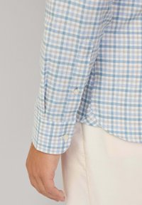 Light blue and white checkered shirt with long sleeves. Features button cuffs and a curved hem. Made from a lightweight fabric.