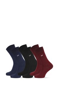 Trzy pary skarpet załogowych w kolorach granatowym, czarnym i bordowym, charakteryzujące się gładką teksturą oraz logo umieszczonym na górze.