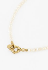 Süßwasserperlenkette mit einem goldenen Toggle-Verschluss. Die Perlen sind unregelmäßig geformt und zeigen eine sanfte weiße Farbe mit einem subtilen Glanz.