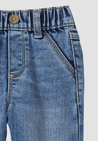 Džinsi ir izgatavoti no denima, ar zilu mazgāšanu, elastīgu jostasvietu, bronzas pogu aizdari, kontrastējošu šuve un divām sānu kabatām.