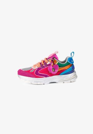 Kolorowy sneaker z różowymi, fioletowymi, pomarańczowymi, zielonymi i niebieskimi panelami, brzoskwiniowymi sznurówkami, białą podeszwą oraz różową zawieszką w kształcie serca przymocowaną z boku.
