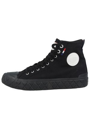 Zapatilla negra de lona alta con suela de goma, parche circular blanco con logo y detalle cosido en rojo, blanco y azul cerca de los cordones.