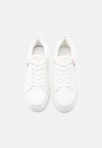 Zapatillas blancas con laterales texturizados, diseño con cordones, bordado floral rosa y detalles en dorado. Punta redondeada y cuello acolchado para mayor comodidad.