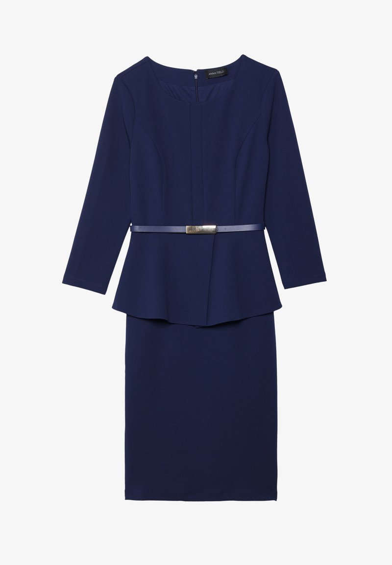 Robe bleu marine à manches longues, design peplum structuré et ceinture plate avec un accent métallique à la taille. Texture de tissu lisse.
