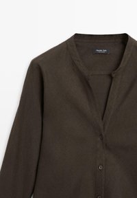Chemise marron à manches longues avec boutons et col bandé, en tissu de lin, étiquetée Massimo Dutti, présentée sur un fond blanc.