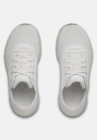Scarpe sportive bianche con tomaia in rete traspirante, lacci piatti, punta arrotondata e suola in gomma verde menta, caratterizzate da un design semplice e texturizzato.