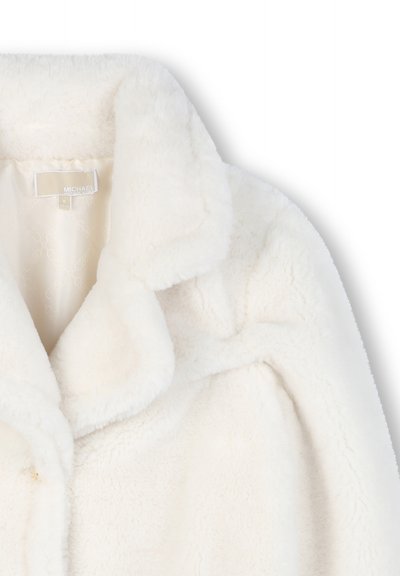 Close-up of a white faux fur coat with wide collar and visible smooth satin lining inside the neck area.