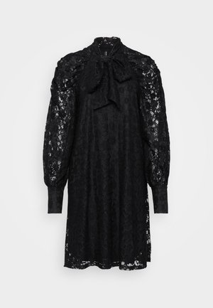 Schwarzes Spitzenkleid mit hohem Hals und Schleife, puffigen langen Ärmeln und entspannter Silhouette. Strukturiertes Muster im gesamten Kleid.