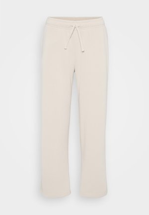 Crème-kleurige recht gesneden sweatpants met elastische tailleband en trekkoord op een effen witte achtergrond.