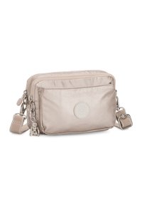 Compact beige crossbody bag made of glossy nylon, featuring two zippered compartments, a decorative charm, and a detachable strap.