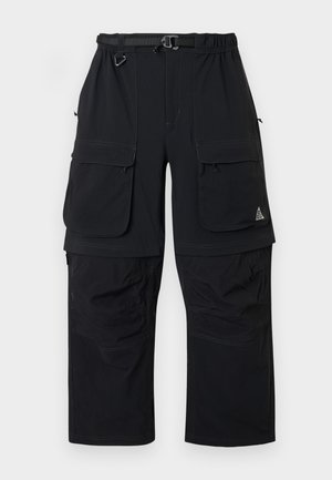 Czarne spodnie cargo z wieloma klapami, regulowanym paskiem i odpinanymi nogawkami dla większej wszechstronności.