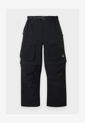 Czarne spodnie cargo z wieloma klapami, regulowanym paskiem i odpinanymi nogawkami dla większej wszechstronności.
