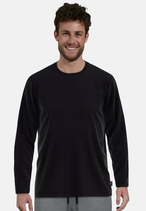 Schwarzes Langarmshirt mit glatter Textur und Rundhalsausschnitt, kombiniert mit grauer Hose, mit lässiger Passform und minimalen Designdetails.