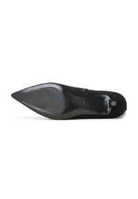 Zapato de tacón alto negro con punta afilada, parte superior de ante y suela negra lisa y brillante que presenta patrones de agarre texturizados.