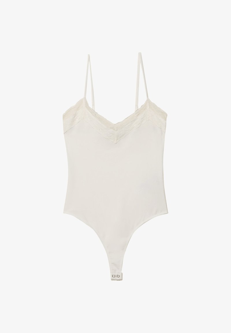 Body bianco realizzato in tessuto morbido, con bordi in pizzo su un décolleté a V, spalline regolabili e chiusura a pressione sul fondo.
